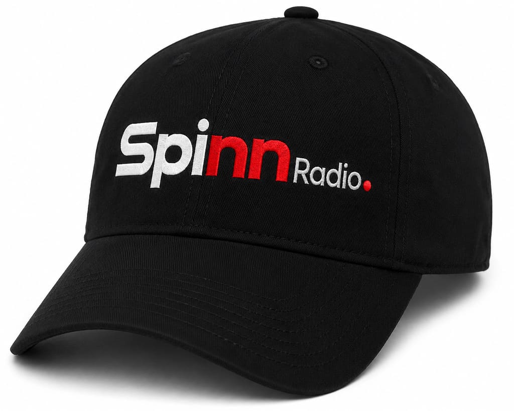 Black cap with the Spinn Radio wordmark embroidered across the front, white type with the red nn and red period